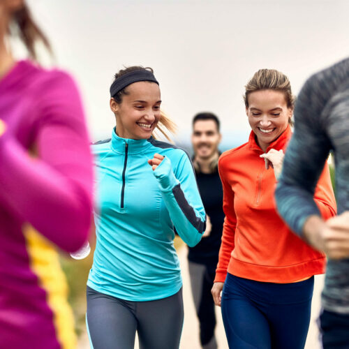 happy-athletic-women-having-fun-while-jogging-with-group-people-nature